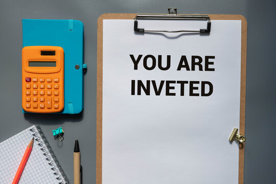 businessman holding a card with text YOU ARE INVETED