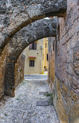 Obraz premium Narrow cobblestone alley with stone arches in the Rhodes Old town, Greece