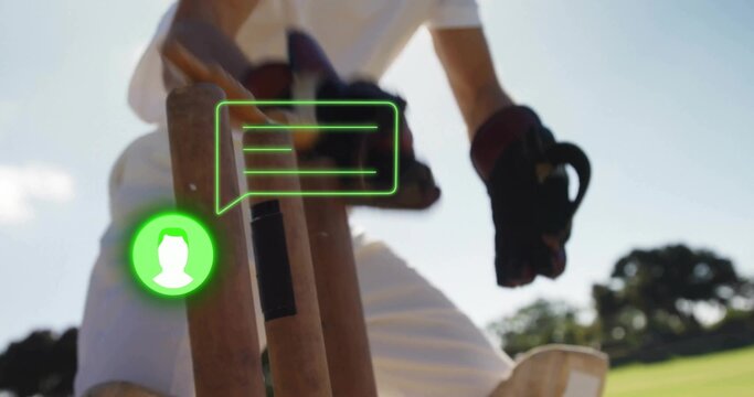 Standing cricket batter in white kit, dark gloves holding bat at wickets, stumps, green overlay