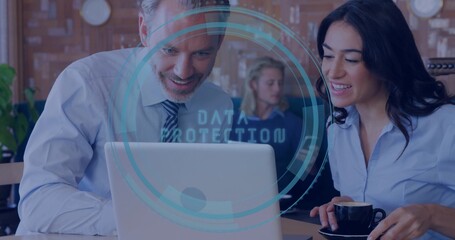 Reviewing coworkers in business attire leaning over laptop at cafe, cup, DATA PROTECTION overlay