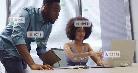 Pointing woman sleeveless typing on laptop in office, leaning man holding tablet, pad, social icons