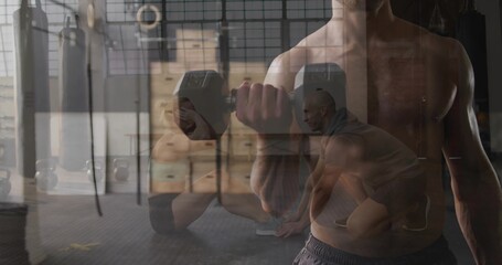 Holding hex dumbbell, shirtless man curling forearm at warehouse gym, with plyo boxes and rings