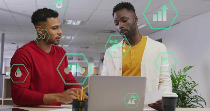 Discussing coworkers in red and cardigan at open-plan office leaning over laptop with data overlays - Powered by Adobe