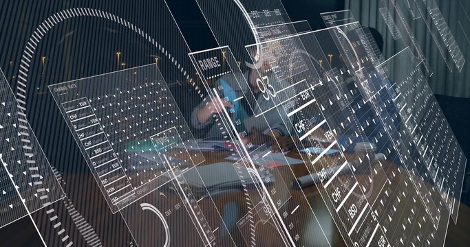 Discussing plan team in collared shirt, dark top at meeting table with laptop, papers, AR panels