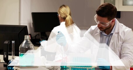 Using pipette, male scientist in white coat and blue gloves pipetting blue reagent at lab bench