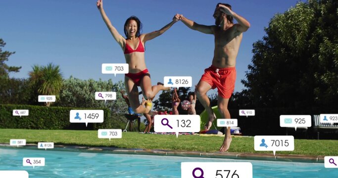 Jumping couple wearing red bikini and trunks holding hands at backyard pool, with social overlays - Powered by Adobe