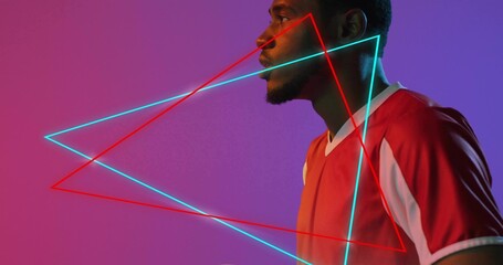 Facing right man wearing red jersey in studio, cyan neon triangles on magenta gradient, copy space
