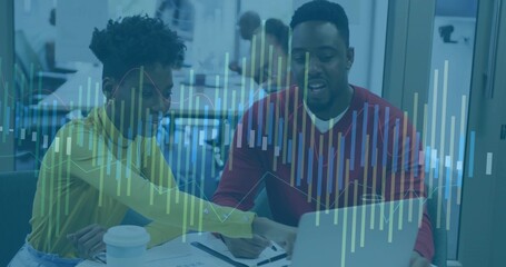 Collaborating team wearing yellow top and red sweater leaning over laptop in office data overlay