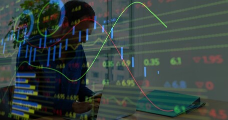 Comparing man in dark sweater checking smartphone, open laptop and binder near window with charts