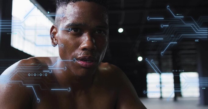 Resting shirtless male athlete catching breath in warehouse gym, sweat glistening, HUD overlaying