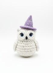 Handmade crochet owl toy wearing a purple wizard hat on a white background, isolated and whimsical design