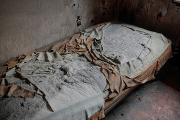 Heavily soiled and debris-covered mattress showing extreme neglect and deterioration