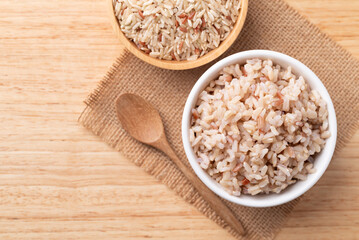 Cooked Thai brown rice in a bowl on wooden background, Healthy eating