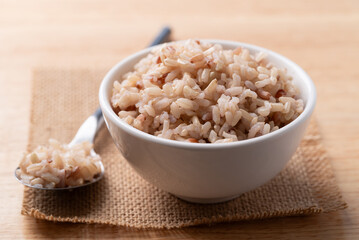 Cooked Thai brown rice in a bowl with spoon, Healthy eating
