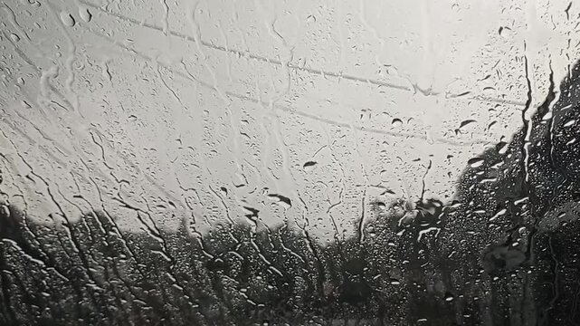 Rain falling on a textured stone pavement, creating ripples and reflections on the wet surface. Natural and atmospheric footage suitable for backgrounds, weather themes, or storytelling