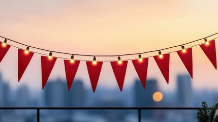 Christmas red pennant flag and string lights create festive atmosphere on balcony at sunset with city skyline in background