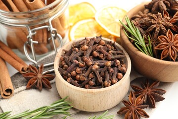 Different spices, fresh rosemary and dry orange slices for mulled wine on table, closeup