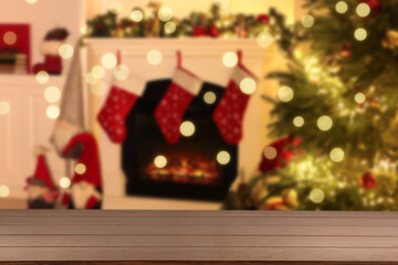 Empty wooden table against blurred room with Christmas tree, bokeh lights. Space for design