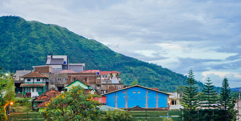 beautiful view of a village at the foot of a hill covered in mist