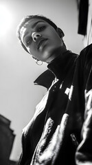 Naklejka premium Confident Look: Captured in monochrome, a bold individual gazes upwards, embodying strength and self-assurance, a study in urban cool. 