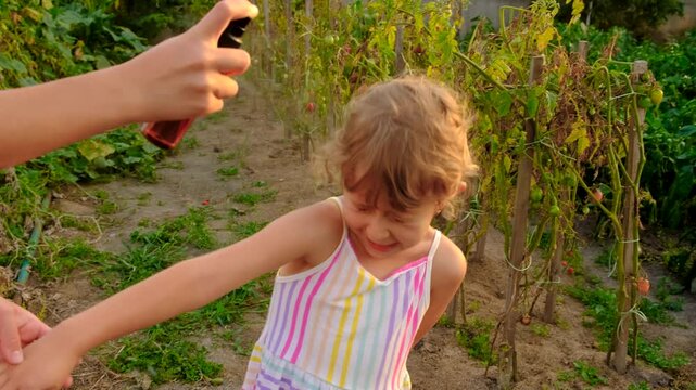 Child spraying mosquito repellent. Selective focus.