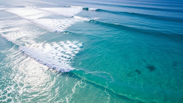 Aerial View of Clear Blue Ocean Waves Rolling Onto Sandy Shore