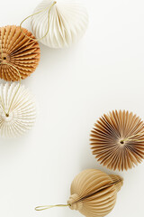 Paper Christmas Ornaments neutral pastel color, hanging New Year decorations as round balls, flashlights, Christmas baubles. Minimal aesthetic holidays pattern, festive top view beige monochrome