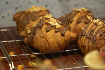 Close up photo of tray of golden brown, flaky and look freshly baked croissants in bakery.