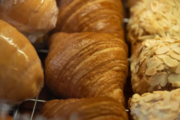 Close up photo of tray of golden brown, flaky and look freshly baked croissants in bakery.