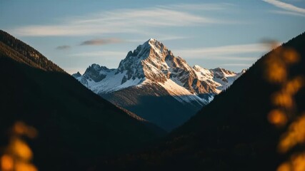 Stunning panoramic view of a snowy mountain peak illuminated by warm sunrise light. Serene alpine wilderness scene with silhouetted forest hills and golden autumn bokeh - Powered by Adobe