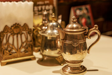 レトロ喫茶店のテーブルに並ぶアンティーク調のポットとナプキンスタンド

