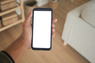 Hand holding smartphone in bright indoor setting