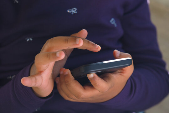 A child engages with a smartphone, tapping the screen with fingers - Powered by Adobe