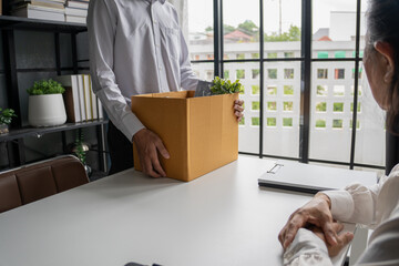 Employees put things in boxes in the office. After resigning from work
