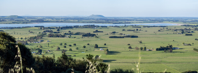A wide panoramic view across the Western Victorian Volcanic Plains near Camperdown Victoria, showcasing expansive green farmland, lakes, and rolling volcanic formations. Rural landscape in Australia