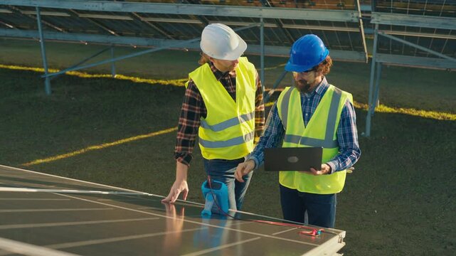 Engineers inspect solar panels at renewable energy site in sunny California