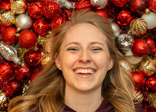 content creator capturing festive moments with cheerful woman amidst holiday adornments for social media