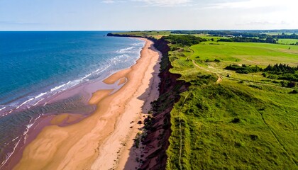 Aerial view of a beach with red cliffs meeting lush green fields on a sunny day