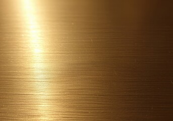 Close-up shot of a brushed metal surface with a golden hue, showing fine lines.