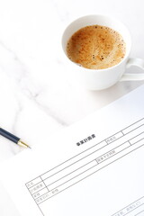 新規事業の立ち上げに先立ち、コーヒーを飲みながら、事業計画書を作成している起業家のイメージ
