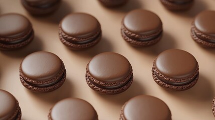 Fototapeta premium close-up of glossy chocolate macarons arranged in neat rows on a warm beige surface conveying indulgence and elegant temptation