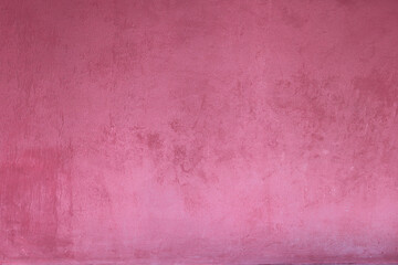 A textured pink wall, with a rough, stucco-like surface and subtle variations in color.