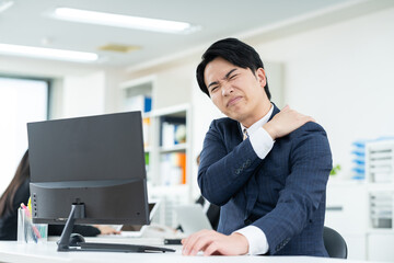 肩こりの若いビジネスマン