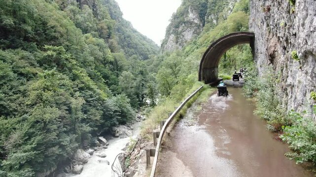Aerial view of quadrocycle goes on abandoned road to Krasnaya Polyana in Sochi. Russia.