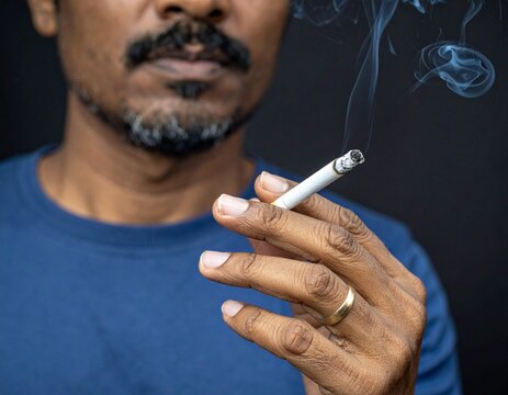 A close-up shows a man holding a lit cigarette with curling smoke, emphasizing the act of smoking.