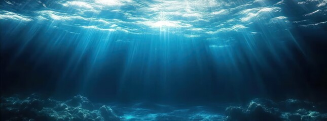 Sunlight piercing a turquoise ocean surface, beams of light illuminating a rocky seabed in calm deep blue waters, evoking tranquility and quiet mystery