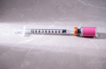 Single Use Syringe Next to Small Glass Vial