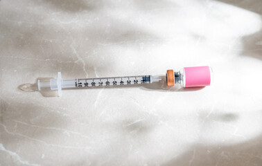 Single Use Syringe Next to Small Glass Vial