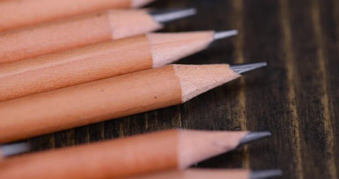 pencils with a black lead on a black pine board , stacked pencils made of wood and a lead made of graphite