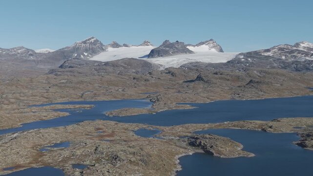 Areal footage of snow covered mountain peaks in Jotunheim National Park, Norway